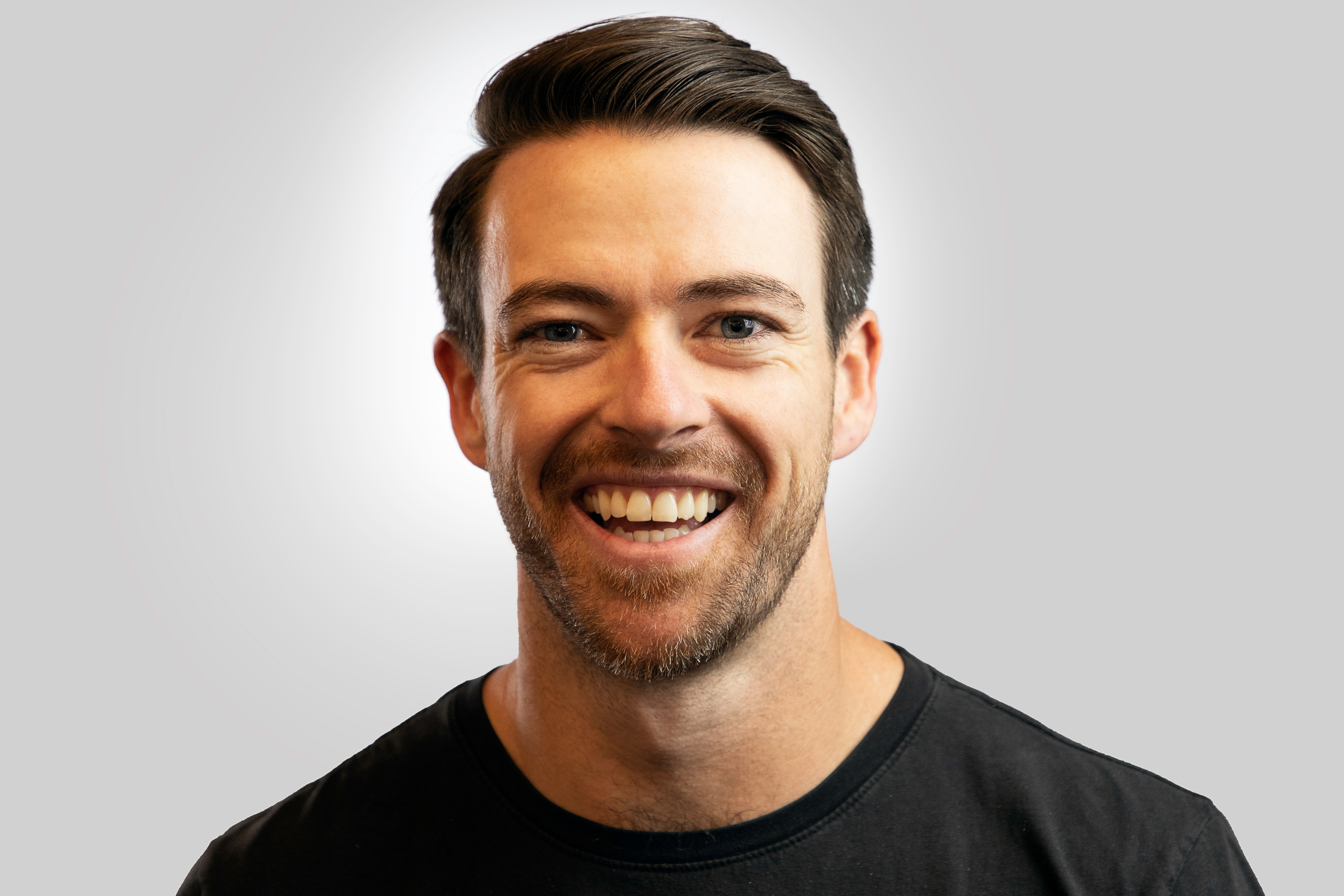 Portrait of a man with glasses wearing a gray shirt.
