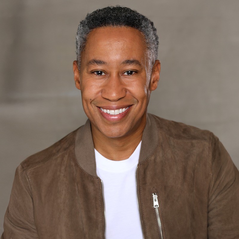 Portrait of a man with glasses wearing a gray shirt.