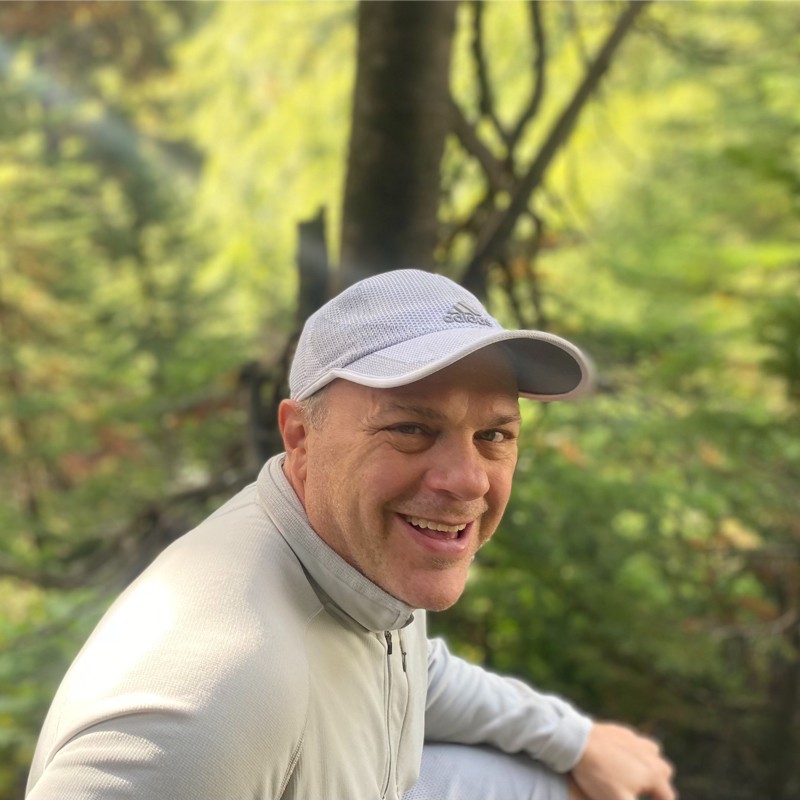 Portrait of a man with glasses wearing a gray shirt.